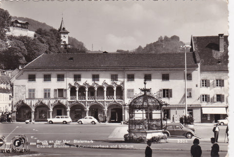AK Bruck an der Mur. Eiserner Brunnen mit Kornmesserhaus und Uhrturm.